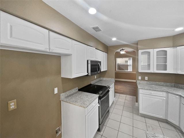 kitchen with ceiling fan, stainless steel appliances, light stone counters, white cabinets, and light wood-type flooring