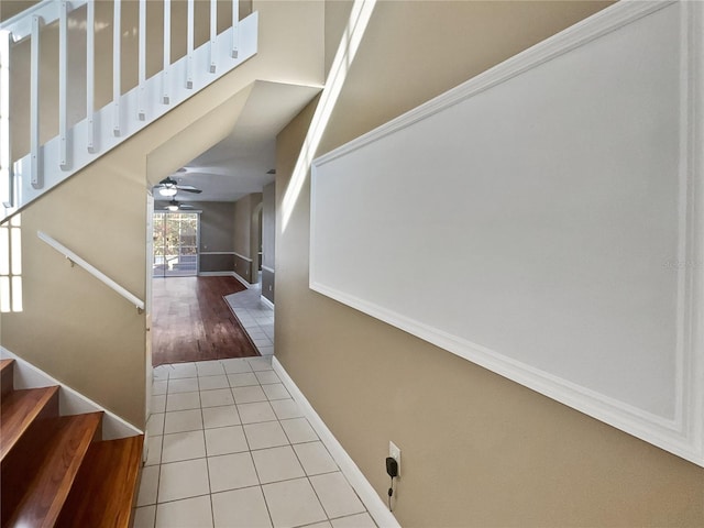 staircase with wood-type flooring and ceiling fan