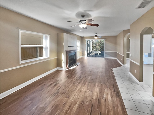 unfurnished living room with hardwood / wood-style flooring and ceiling fan