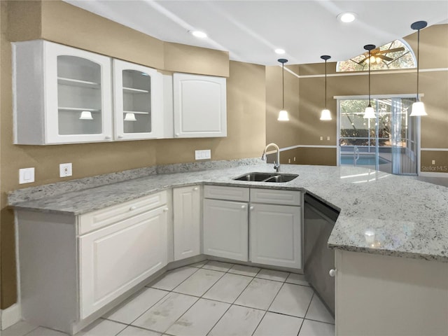 kitchen featuring white cabinets, stainless steel dishwasher, kitchen peninsula, and sink