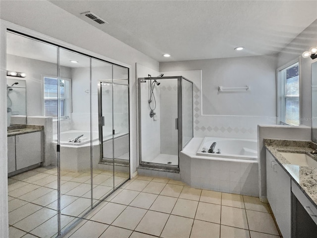 bathroom with tile patterned floors, vanity, independent shower and bath, and a textured ceiling