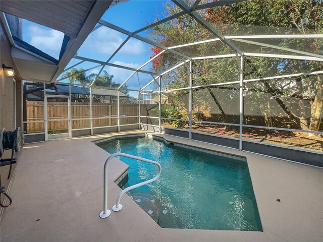 view of swimming pool with a patio area and glass enclosure