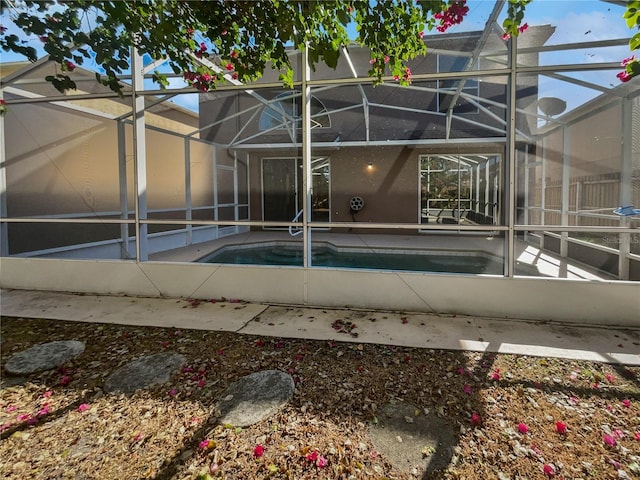 view of swimming pool with glass enclosure and a patio area