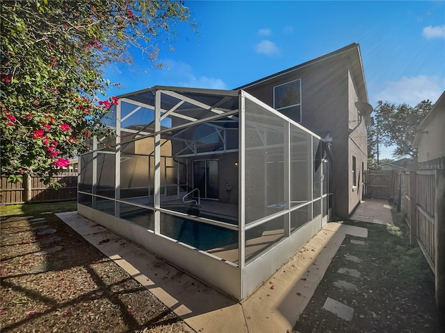 view of home's exterior with glass enclosure