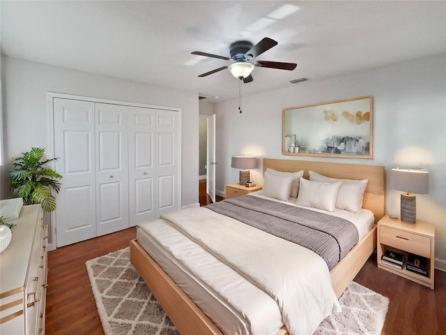 bedroom with a closet, dark hardwood / wood-style floors, and ceiling fan