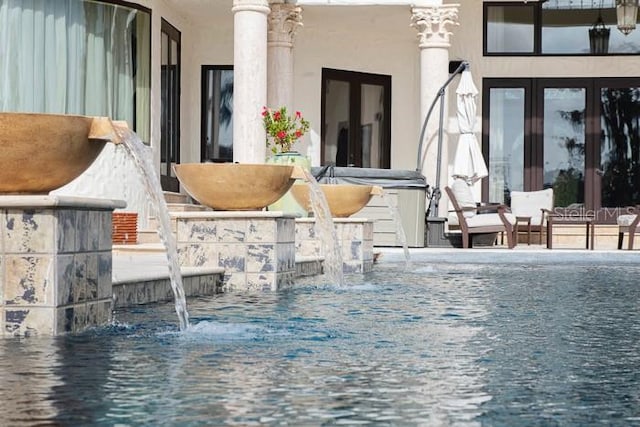 exterior space with french doors and pool water feature