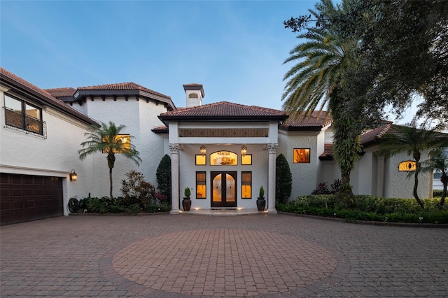 mediterranean / spanish house featuring a garage and french doors