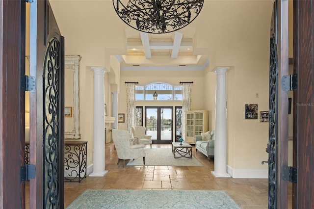 foyer entrance featuring beam ceiling, decorative columns, a high ceiling, coffered ceiling, and french doors