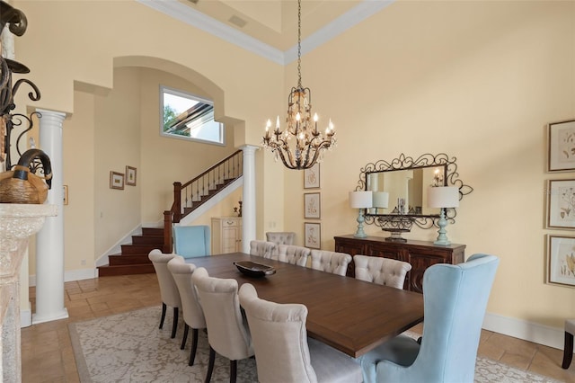 dining room with crown molding, ornate columns, a chandelier, and a high ceiling