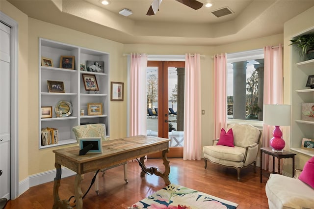 home office with hardwood / wood-style flooring, a healthy amount of sunlight, a tray ceiling, and french doors