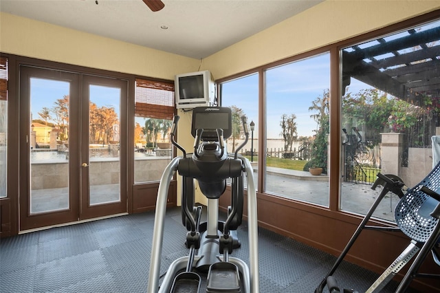 workout area featuring ceiling fan, dark carpet, and french doors