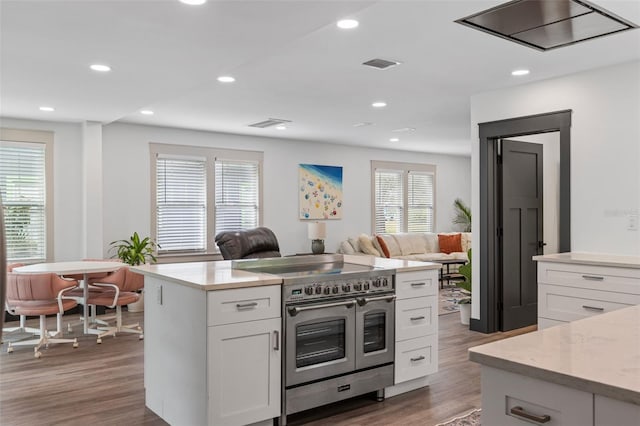 kitchen with dark wood-style floors, visible vents, open floor plan, white cabinets, and double oven range