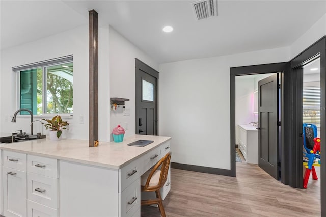 interior space featuring light wood-style floors, plenty of natural light, visible vents, and baseboards