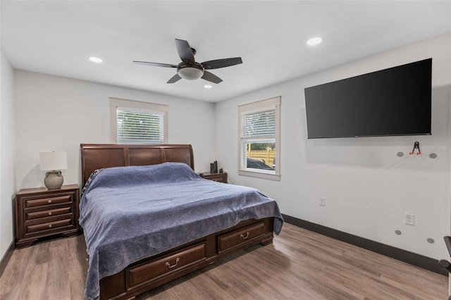 bedroom featuring recessed lighting, multiple windows, baseboards, and wood finished floors