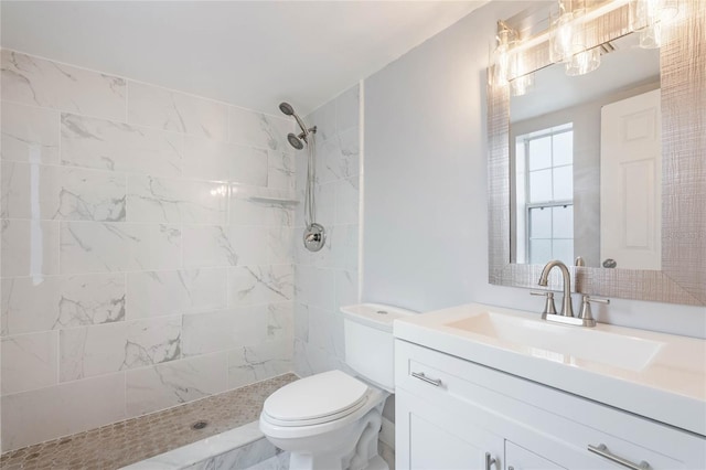 bathroom featuring vanity, toilet, and tiled shower