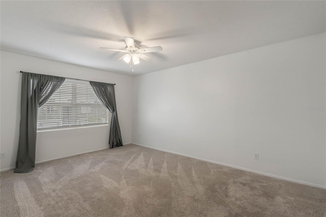 empty room with ceiling fan and light carpet