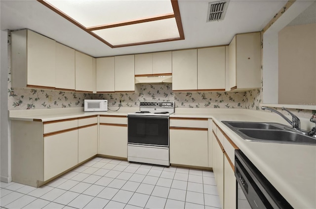 kitchen featuring white appliances, sink, and cream cabinets