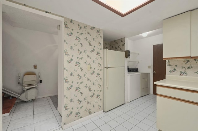 laundry area with separate washer and dryer and light tile patterned flooring