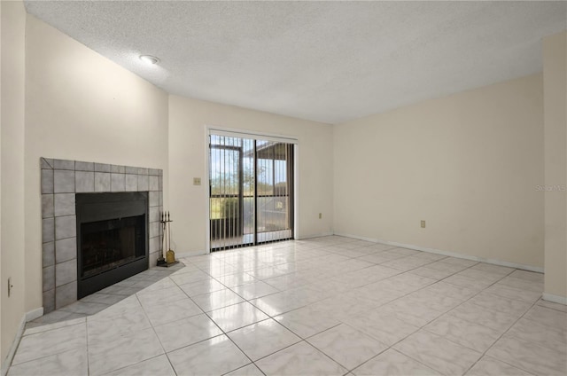 unfurnished living room with light tile patterned floors, a textured ceiling, and a tiled fireplace