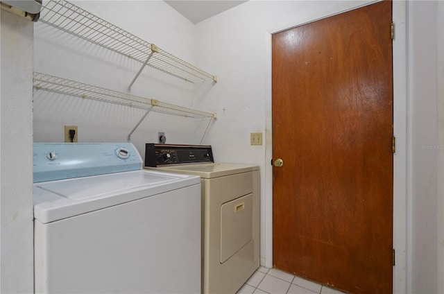 laundry area with light tile patterned floors and washer and clothes dryer