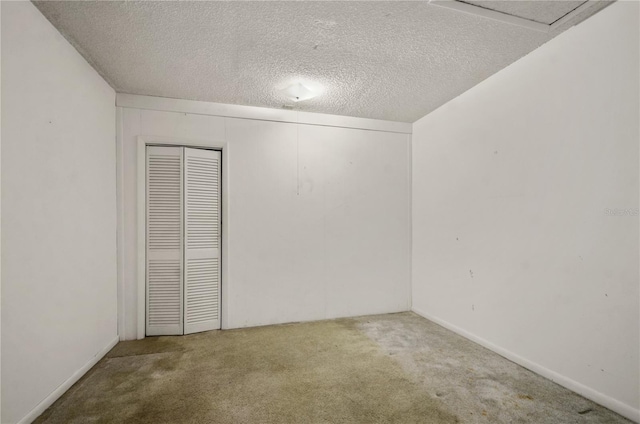 empty room with carpet flooring and a textured ceiling