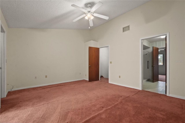 unfurnished bedroom featuring a spacious closet, ceiling fan, carpet floors, and a textured ceiling