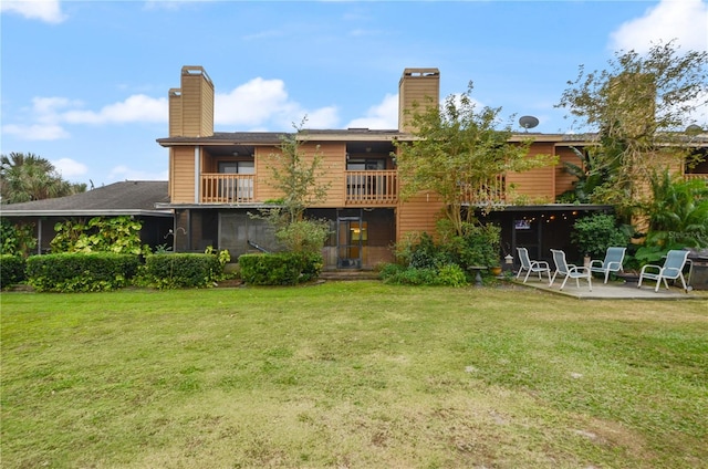 back of property featuring a patio, a balcony, and a lawn