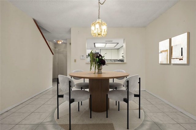 tiled dining area featuring an inviting chandelier