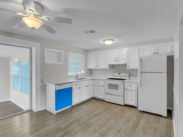 kitchen featuring sink, white cabinets, light hardwood / wood-style floors, and white appliances