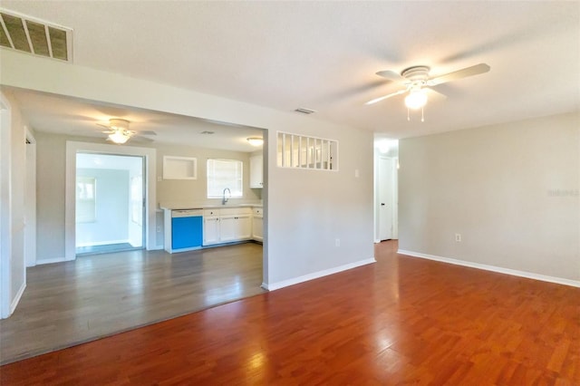 unfurnished living room featuring ceiling fan, sink, and dark hardwood / wood-style floors