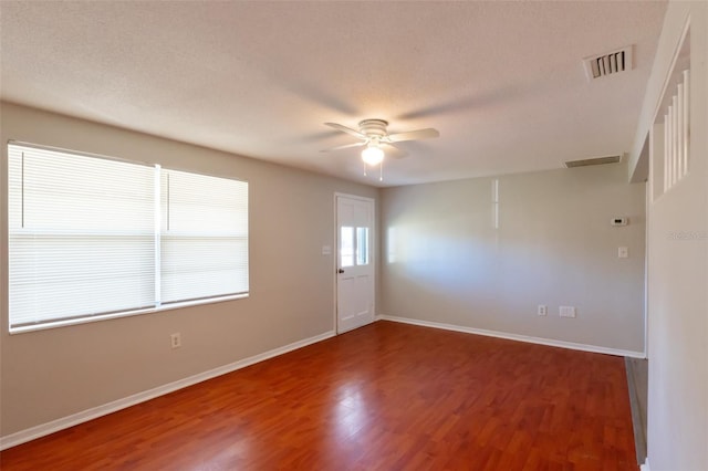 spare room with ceiling fan, dark wood-type flooring, and a textured ceiling