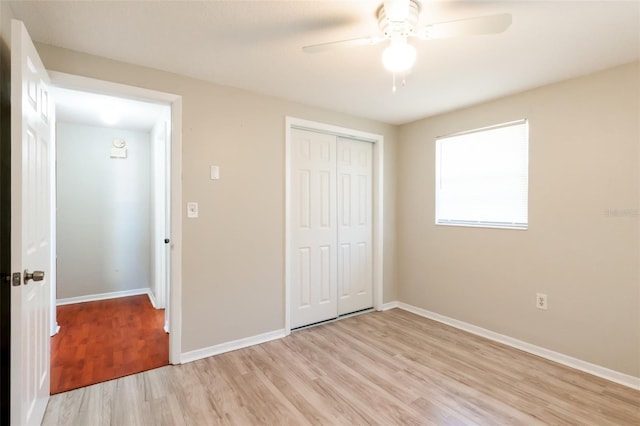 unfurnished bedroom featuring ceiling fan, light hardwood / wood-style floors, and a closet