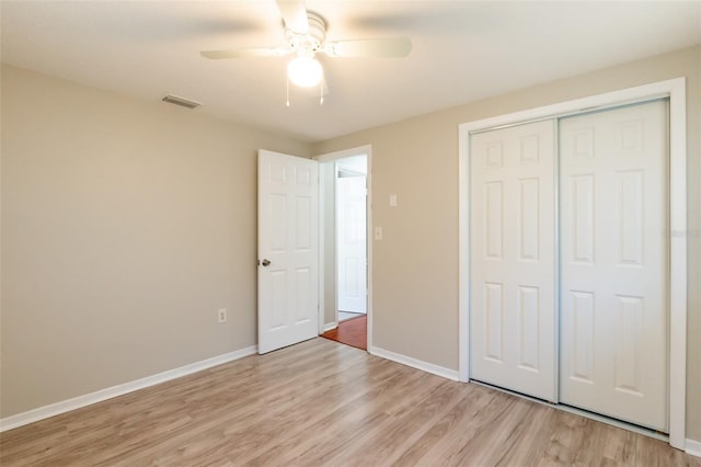 unfurnished bedroom featuring ceiling fan, light wood-type flooring, and a closet