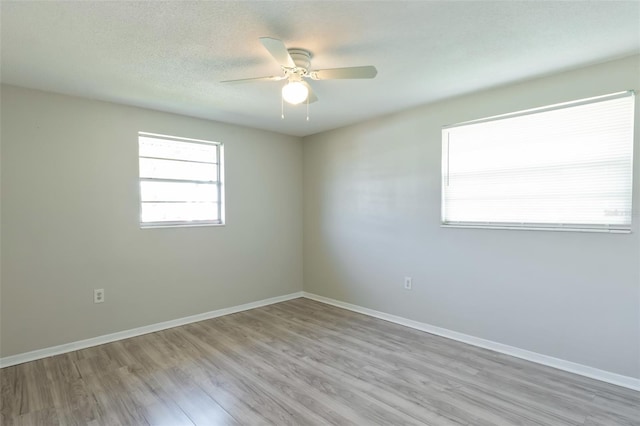 empty room featuring ceiling fan, a textured ceiling, and light hardwood / wood-style flooring