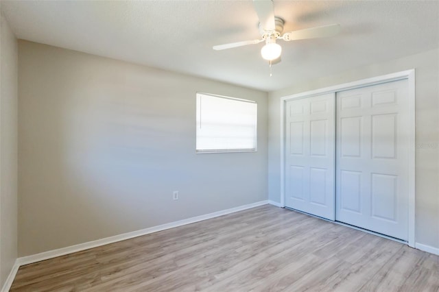 unfurnished bedroom with a textured ceiling, a closet, light hardwood / wood-style floors, and ceiling fan