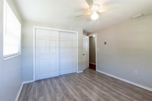 unfurnished bedroom featuring ceiling fan, light hardwood / wood-style flooring, and a closet