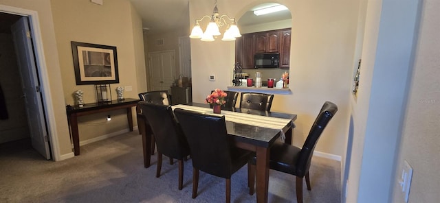 dining space with carpet floors and an inviting chandelier