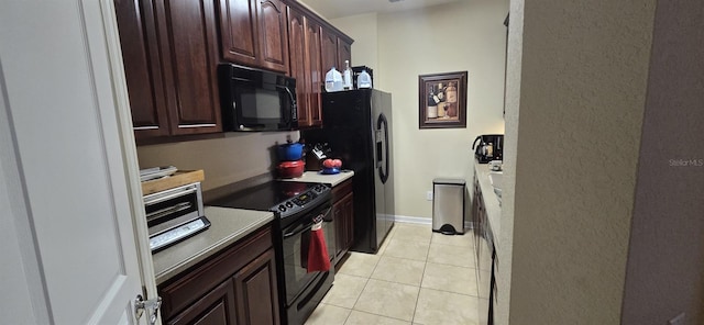 kitchen with light tile patterned floors, dark brown cabinets, and black appliances