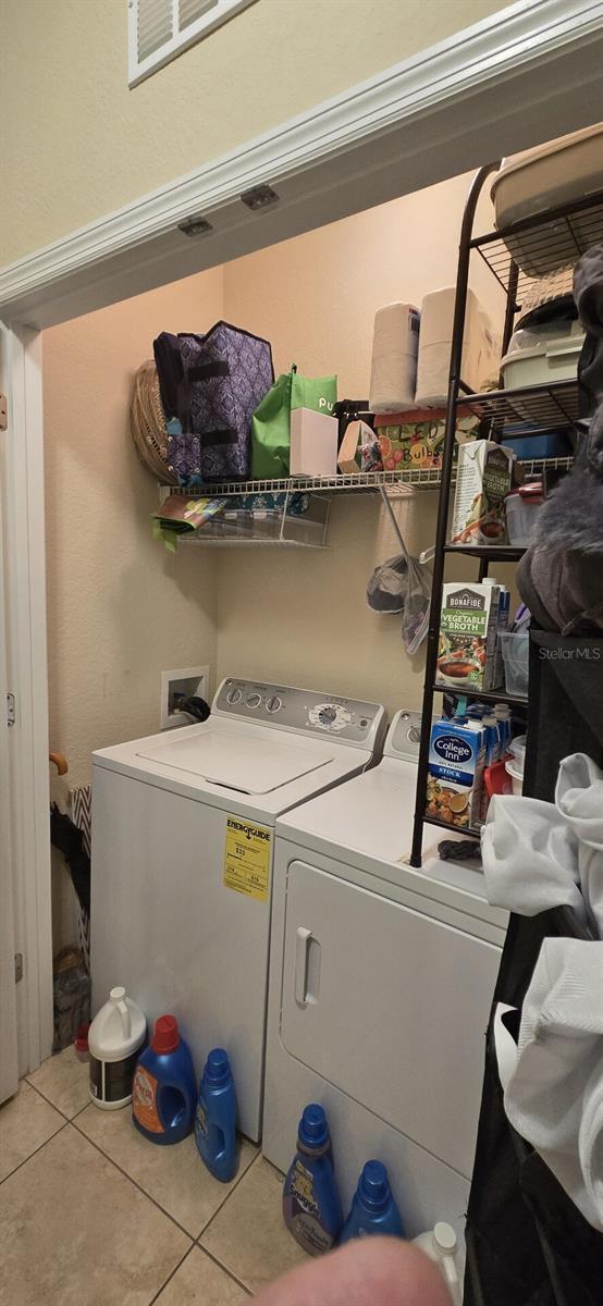 laundry room featuring washer and clothes dryer and light tile patterned flooring