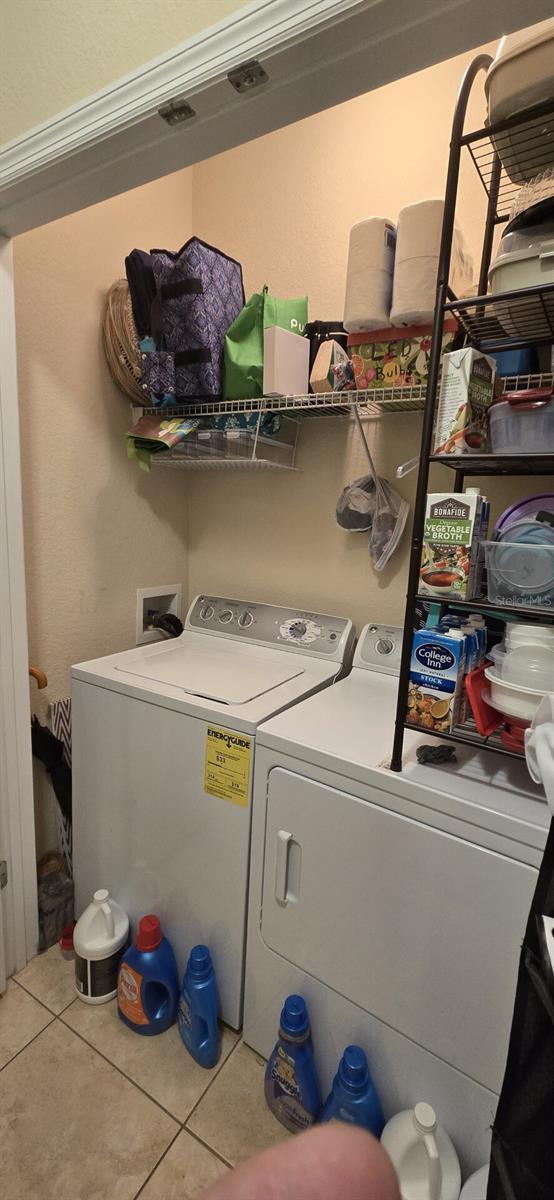 washroom with light tile patterned floors and washer and dryer