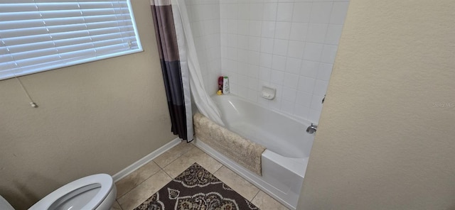 bathroom featuring tile patterned flooring, shower / tub combo, and toilet