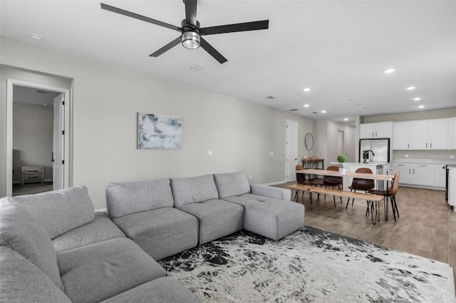 living room featuring light wood-type flooring and ceiling fan