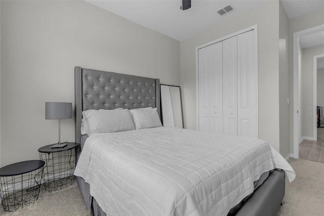 carpeted bedroom featuring ceiling fan and a closet