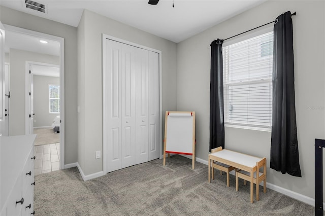 interior space featuring ceiling fan and light colored carpet