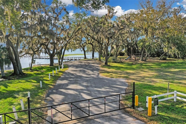 view of property's community featuring a water view and a lawn