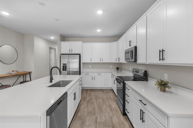 kitchen featuring white cabinetry, stainless steel appliances, a sink, and recessed lighting