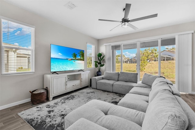 living area with baseboards, a ceiling fan, visible vents, and wood tiled floor