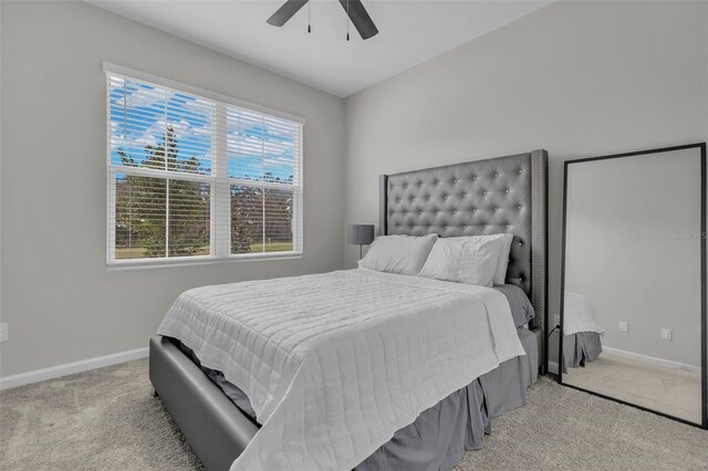 bedroom featuring light carpet, ceiling fan, and baseboards