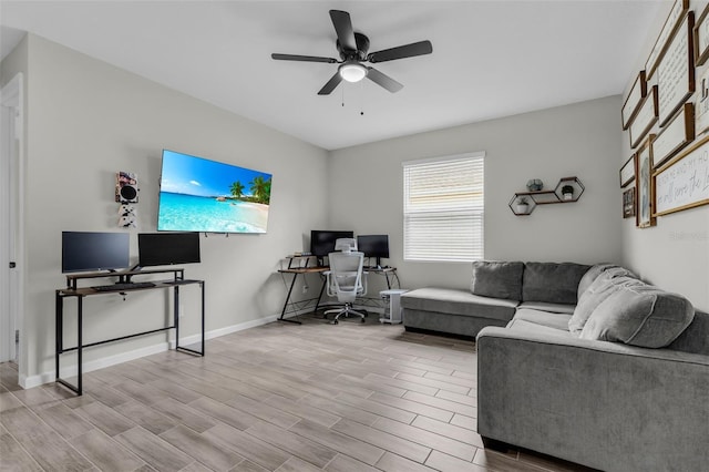 living area with a ceiling fan, wood finish floors, and baseboards