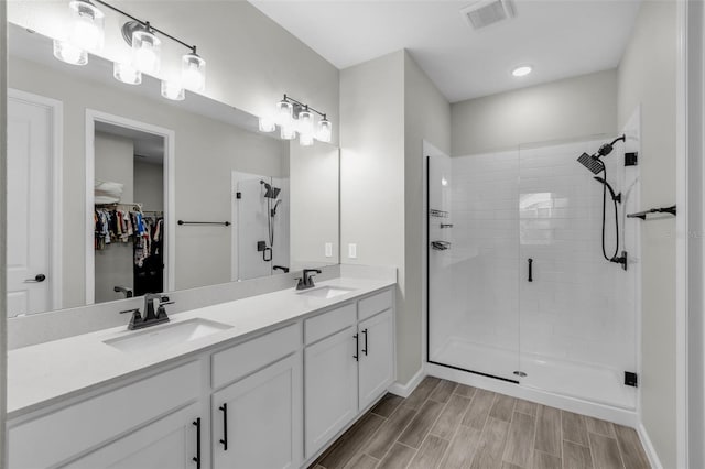 10157 Spring Lake Dr, Clermont, FL 34711 - full bath featuring a stall shower, a spacious closet, double vanity, wood finished floors, and baseboards